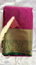 Kanchipuram silk saree featuring a magenta-pink body paired with an elaborate green and gold zari border  (Saree Code - S100)