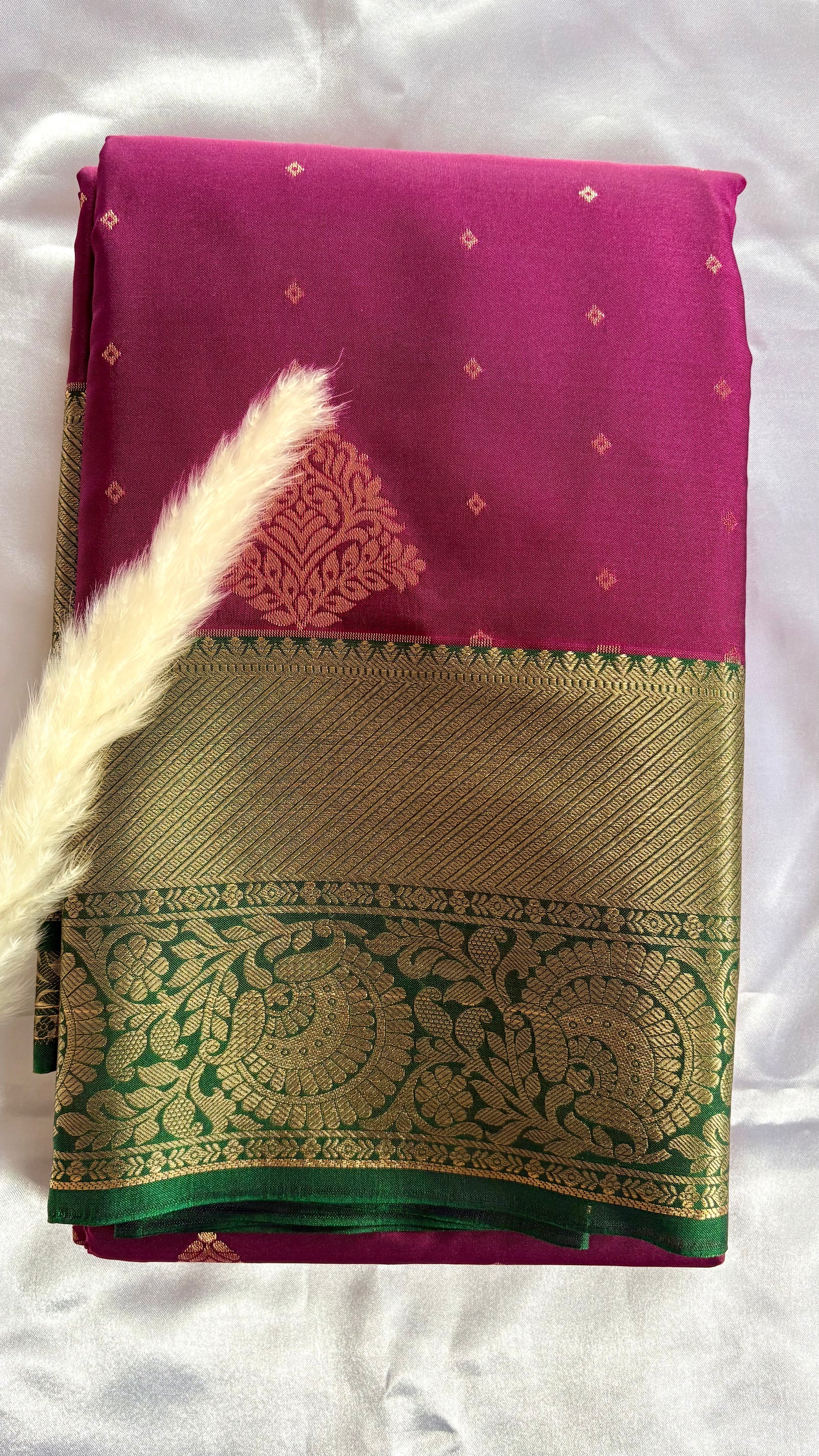 Kanchipuram silk saree featuring a magenta-pink body paired with an elaborate green and gold zari border  (Saree Code - S100)