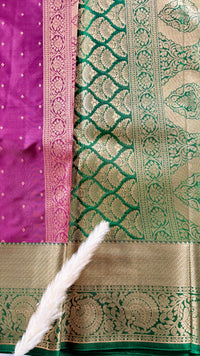 Kanchipuram silk saree featuring a magenta-pink body paired with an elaborate green and gold zari border  (Saree Code - S100)
