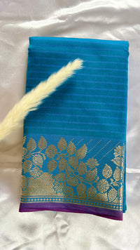 Soft silk saree features a detailed gold zari woven floral border and a subtle horizontal stripes  (Saree Code - S103)