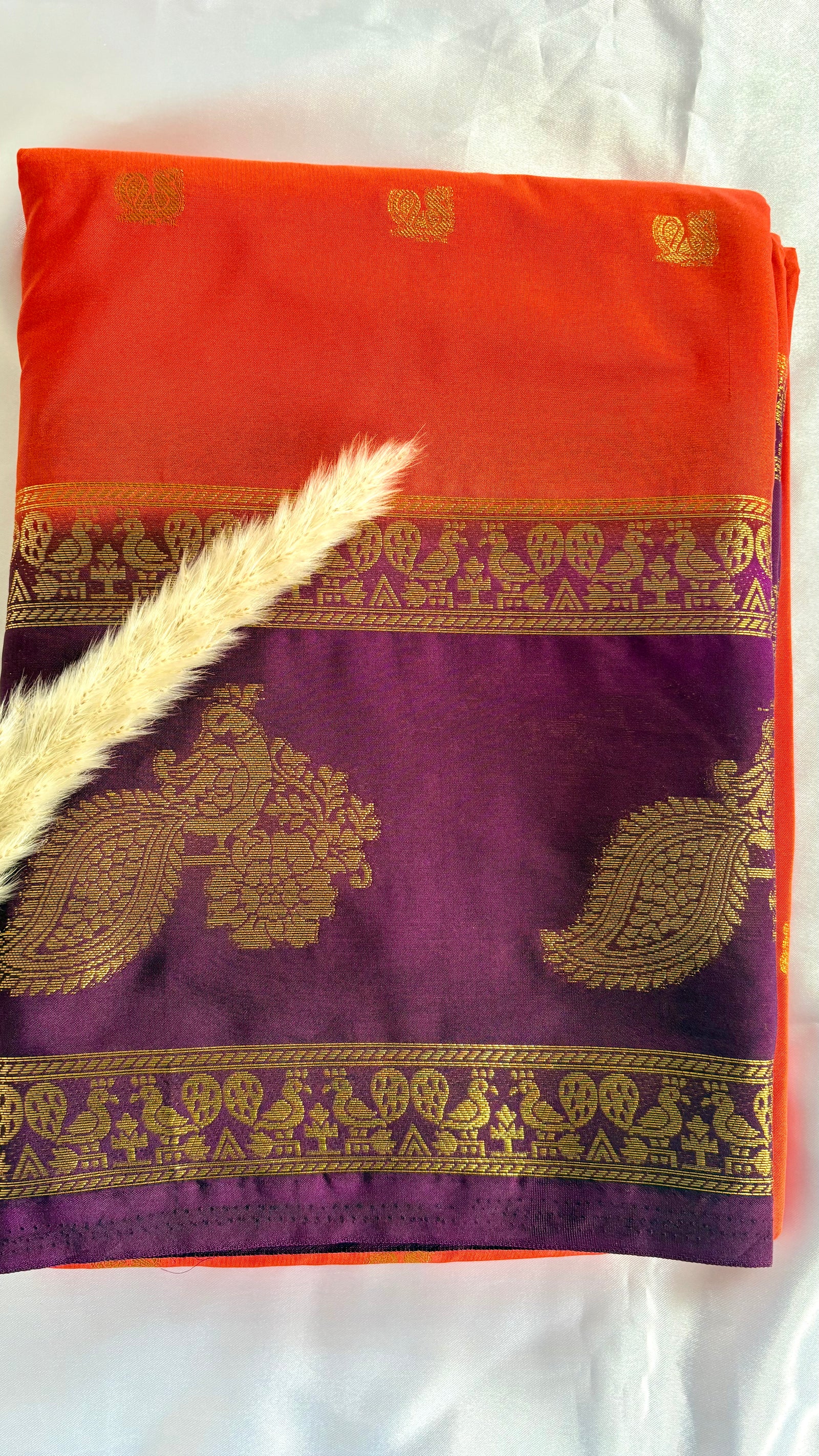 Featuribg an Orange body and a Wine-Coloured Border, Intircately woven with traditional goldern zari motifs (Saree Code - S72)