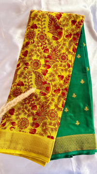Beutiful yellow and green semi mysore crepe silk saree features vibrant floral and bird kalamkari print paired with a rich gold zari border (Saree Code - S71)