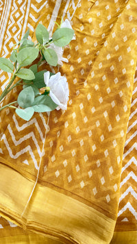 White Geometric zig-zag chevron print pattern warm mustard-brown hue, complemented by a traditional, glossy golden zari border  (Saree Code - S77)