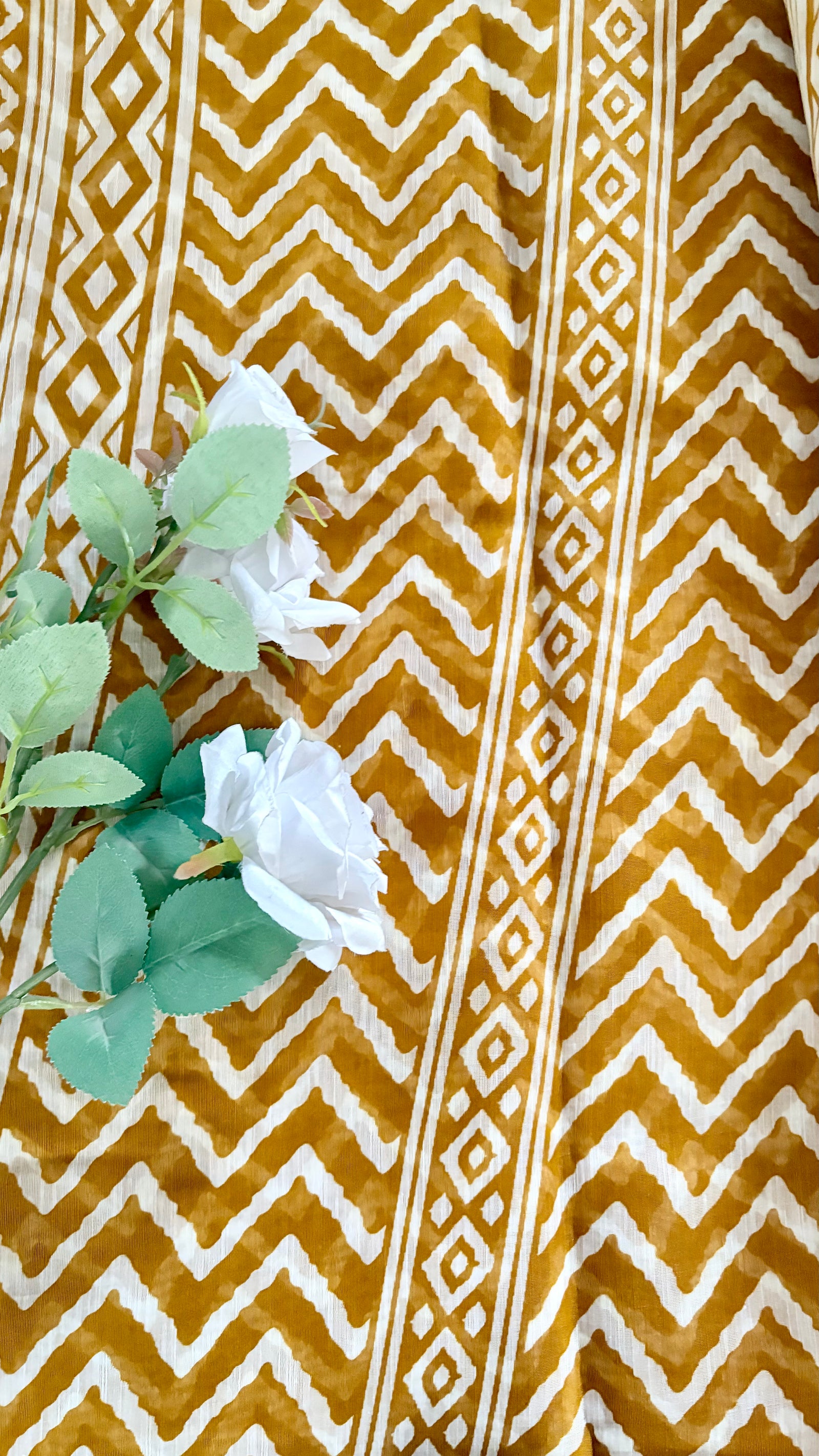 White Geometric zig-zag chevron print pattern warm mustard-brown hue, complemented by a traditional, glossy golden zari border  (Saree Code - S77)