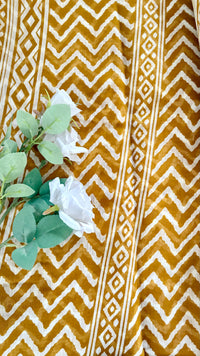 White Geometric zig-zag chevron print pattern warm mustard-brown hue, complemented by a traditional, glossy golden zari border  (Saree Code - S77)