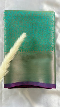 Kanchipuran Tissue silk saree featuring an intricate floral sea green body paired with a contract Lavender Zari Border ( (Saree Code - S92)