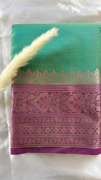 Stunning steal green kanchipuram silk saree featuring an elegant contract pink zari woven border and a matching pallu  (Saree Code - S94)