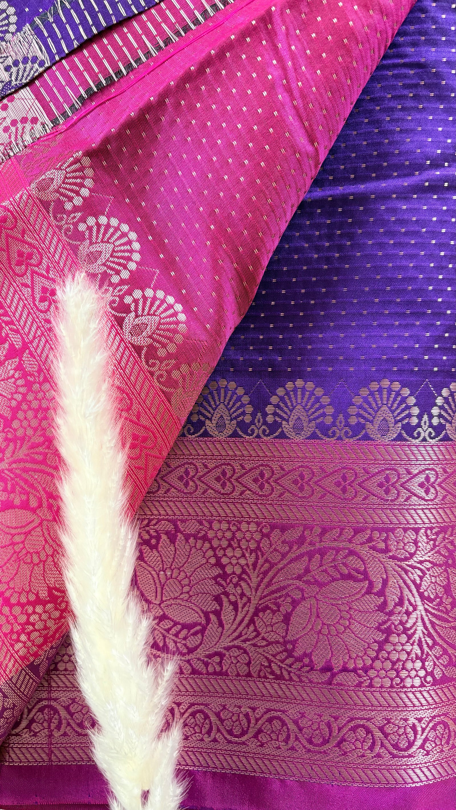 Vibrant purple body decorated with delicate allover woven buttas and a contrasting pastel pink border intricately styled with tradition floral Zari motifs  (Saree Code - S95)