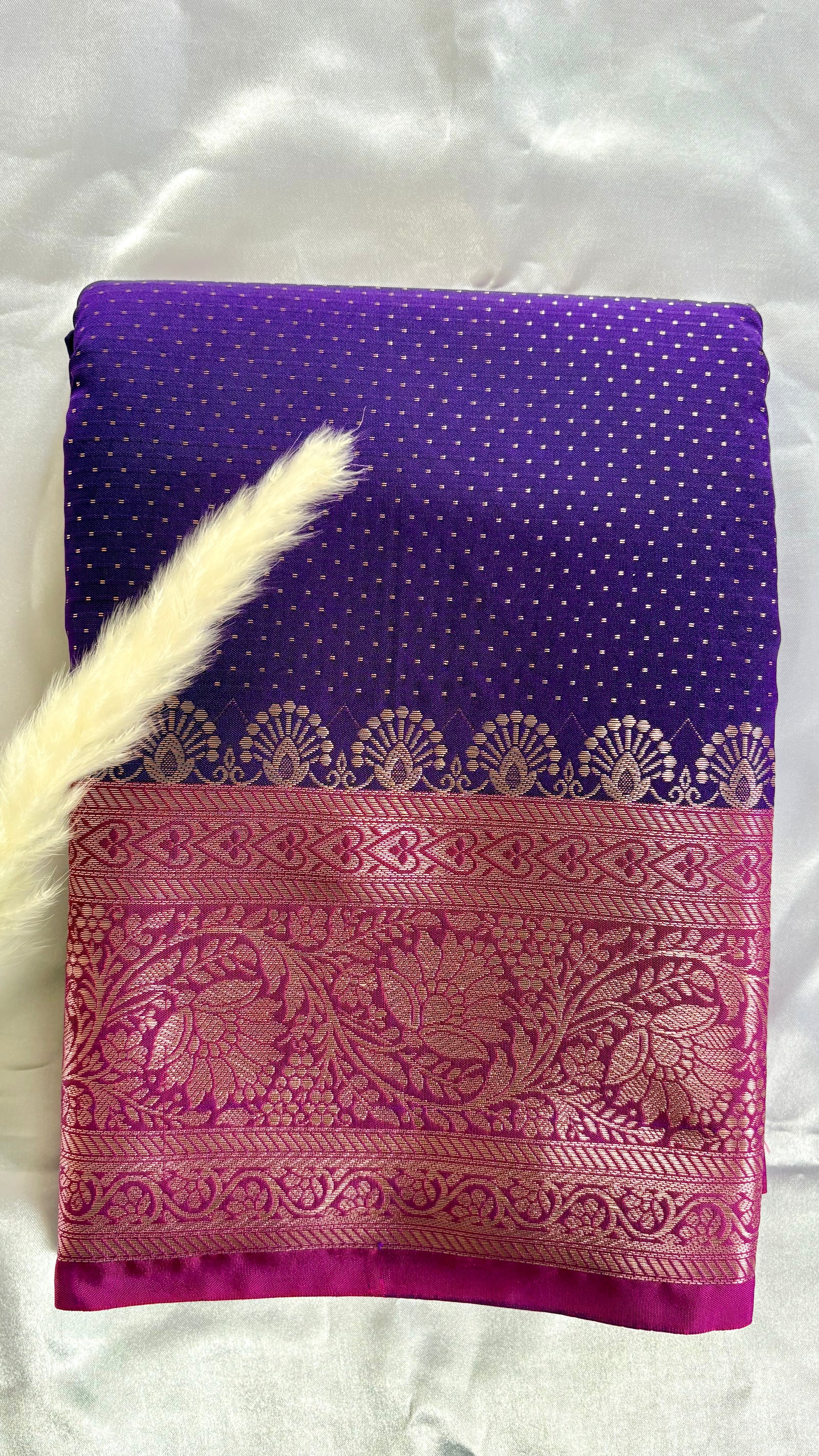 Vibrant purple body decorated with delicate allover woven buttas and a contrasting pastel pink border intricately styled with tradition floral Zari motifs  (Saree Code - S95)